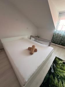 a white bed with a cork on it at Casa Happy in Petroşani