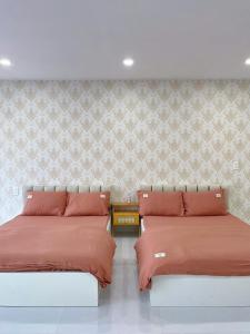 two beds sitting next to each other in a bedroom at Hạt Nắng House - Gò Vấp in Ho Chi Minh City +16 photos
