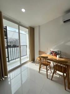 a dining room with a table and a large window at Hạt Nắng House - Gò Vấp in Ho Chi Minh City