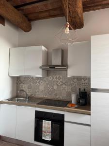 a kitchen with white cabinets and a sink at Principessa in Panicale