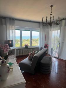 a living room with a couch and a large window at Viola Apartment Monte Felice in Bardolino