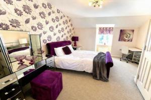 a purple bedroom with a bed and a mirror at The Rosewood in Grays Thurrock