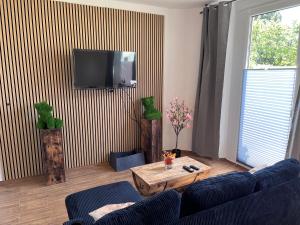 a living room with a couch and a tv on a wall at Appartement zum Grünen Bär klimatisiert in Holzminden