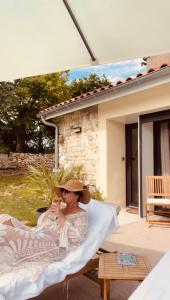 a woman in a hat sitting on a porch at O'Manava Lodge & Bien-Etre in Virac