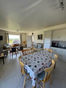 a kitchen and living room with a table and chairs at Meadow View Cottage in Clooncullin Bridge
