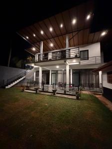 a large white building with a balcony and a yard at SIORA Retreat in Dambulla +16 photos