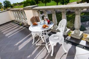 a table and chairs on a balcony with food on it at Tarnóca Kúria in Soponya