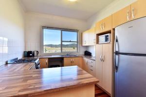 a kitchen with a refrigerator and a counter top at Somerville Wine Cottage Hideaway 3-Bedroom Cottage Near Broke Wineries in Broke