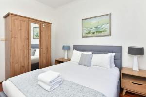 a bedroom with a large white bed and a mirror at Somerville Wine Cottage Hideaway 3-Bedroom Cottage Near Broke Wineries in Broke +13 photos