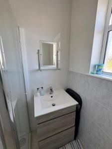 a white bathroom with a sink and a shower at Meadow View Cottage in Clooncullin Bridge +39 photos