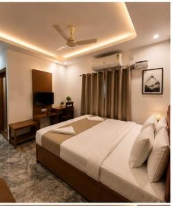 a bedroom with a bed and a desk and a ceiling at Hotel bella rosa in Chengalpattu