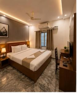 a hotel room with a large bed and a desk at Hotel bella rosa in Chengalpattu