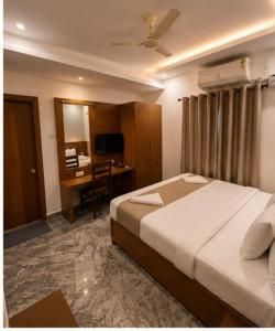 a hotel room with a bed and a desk at Hotel bella rosa in Chengalpattu