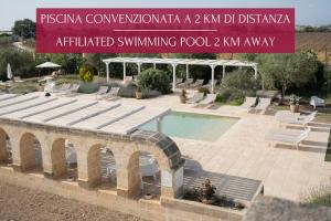 a swimming pool in a yard with a sign at Dimora Storica Palazzo Didonna in Rutigliano