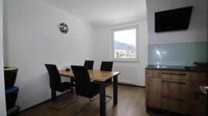 a dining room with a table and chairs and a television at Glöcknerhaus in Sankt Gallen