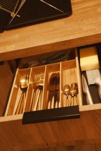 a drawer with utensils in a wooden cabinet at Apartament w Parku 2 in Żywiec