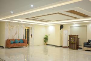 a lobby with a couch and a podium in a room at Dubai Palace Hotel in Sambriāl