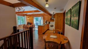 a kitchen and dining room with a wooden table and chairs at Chalet Le Boisé SPA et Rivière in Brownsburg