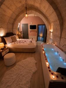 a bedroom with a king sized bed and a tub at novela in stone house in Uçhisar
