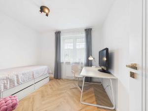a bedroom with a bed and a desk with a computer at Apartament HUZAR 2 in Białystok
