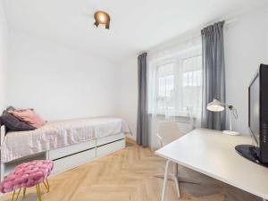 a bedroom with a bed and a desk with a computer at Apartament HUZAR 2 in Białystok +1 photo