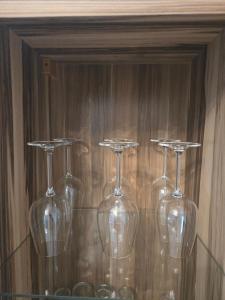 four wine glasses sitting on a glass shelf at Buchenau an der Lahn 