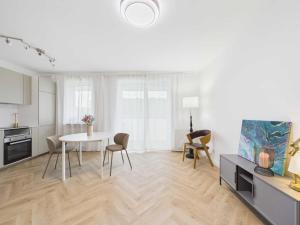a white living room with a table and chairs at Apartament HUZAR 2 in Białystok