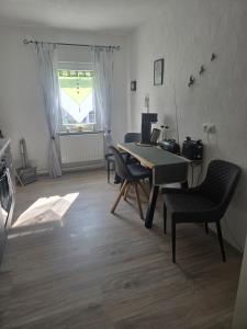a living room with a table and chairs and a window at Buchenau an der Lahn  +6 photos