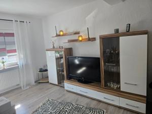 a living room with a flat screen tv on a entertainment center at Buchenau an der Lahn 