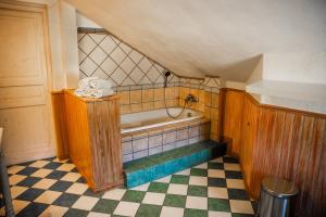 a bathroom with a tub and a checkered floor at Erasmus WaldBlick Ferienhaus mit Ausblick in Saarburg +13 photos