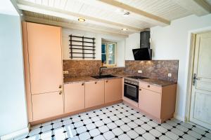 a kitchen with pink cabinets and a tile floor at Erasmus WaldBlick Ferienhaus mit Ausblick in Saarburg