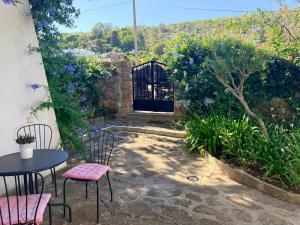 a patio with a table and chairs and a gate at Descansadero in Bolonia