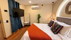 a bedroom with a bed and a flat screen tv at Nam Hotel Boutique Medellin in Medellín