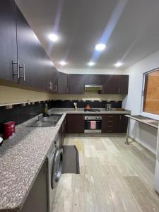 a kitchen with wooden cabinets and a counter top at Appartement cozy in Oujda +8 photos