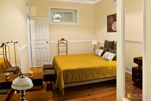 um quarto com uma cama com uma colcha amarela em Safe House em Lisboa