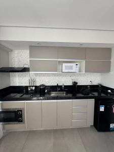 a kitchen with a sink and a microwave at Diamond - Flat Bela Estância in São Lourenço