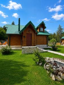 a wooden house with a green roof on a yard at North Forest in Žabljak