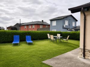 a group of chairs and a table in a yard at El Rincón de Luarca in Luarca