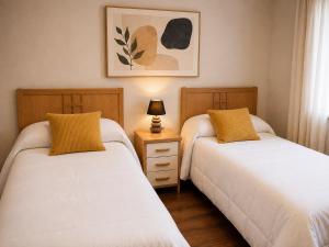 two beds sitting next to each other in a bedroom at El Rincón de Luarca in Luarca