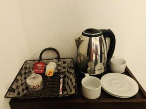 a tray with a tea kettle and cups and plates at wild elephant reach wilpattu in Nochchiyagama