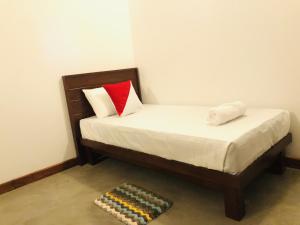 a small bed with two pillows and a rug at wild elephant reach wilpattu in Nochchiyagama