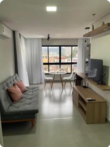 a living room with a couch and a table at Diamond - Flat Bela Estância in São Lourenço