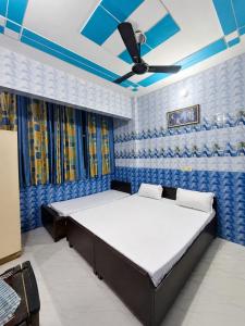 a bedroom with a bed and a ceiling fan at crown house in Phagwāra