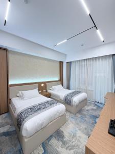 a hotel room with two beds and a desk at Keruen in Almaty +38 photos