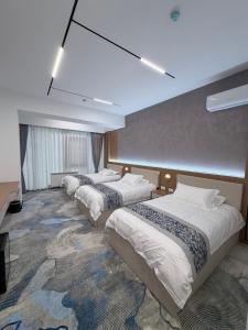 a row of three beds in a hotel room at Keruen in Almaty