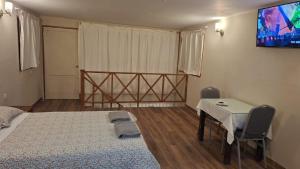 a bedroom with a bed and a table and a tv at Pucayacu Wasi in Sauce