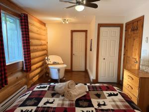a bedroom with a bed and a toilet and a sink at Chalet Le Boisé SPA et Rivière in Brownsburg +14 photos