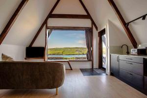 a living room with a couch and a large window at Wild Atlantic Pods in Portmagee
