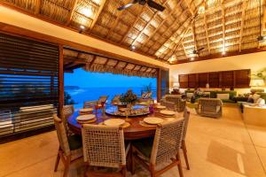 a dining room with a table and chairs and a living room at 2024 - Villa Serena in Santa Cruz Huatulco