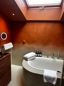 a bathroom with a large bath tub with a skylight at Hotel Le Mathurin in Paris +72 photos